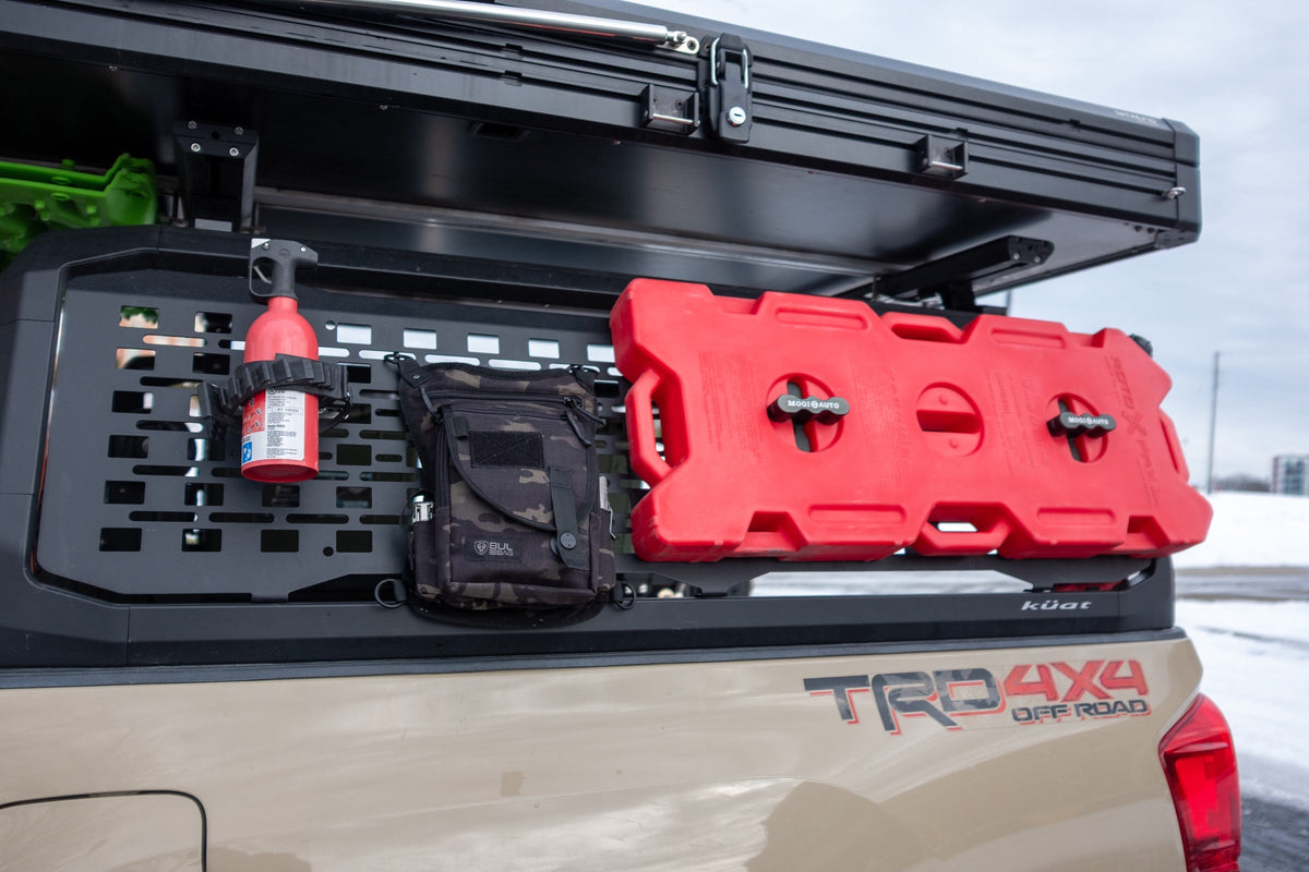 Sportsman on a truck bed rack beside fuel cans
